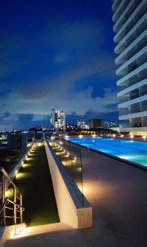 A rooftop pool with a view of a city skyline at dusk. - Exclusive apartment Cartagena de Indias. (Cartagena de Indias)