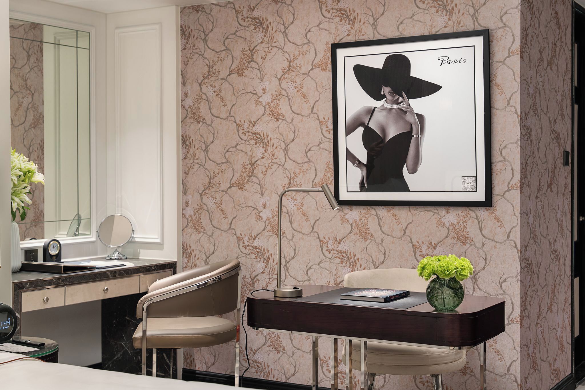 Een moderne badkamer met een wastafel, spiegel en een lijst met een foto aan de muur.