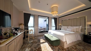 A modern hotel room with a large bed, a small desk with a chair, a bench, and a view of the outdoors. - The Haron Hanoi Boutique Hotel (Hanoi)