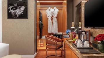 Una habitación de hotel con cama, escritorio, computadora, silla y televisión.