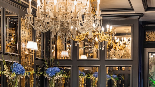 A restaurant interior with multiple dining tables, elegant chandeliers, and mirrored walls. - The Haron Hanoi Boutique Hotel (Hanoi)