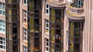 A high-rise building with multiple balconies and large windows.
