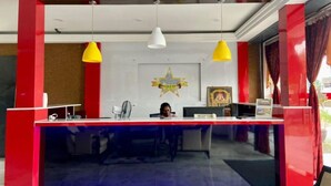 A reception desk with a star decoration, a nameplate, and a framed picture on the wall. - Royals Star Hotel (Seremban)