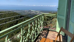 Un balcon avec vue sur une ville côtière et sur un téléphérique.