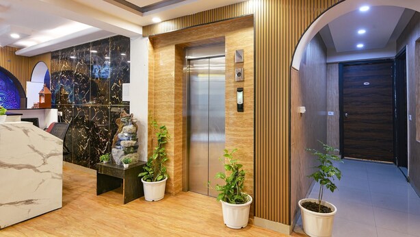 En moderne reception med en marmor disk, elevator og potteplanter.