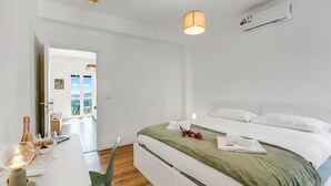 A modern hotel room with a bed, bedside table, and a view of the outdoors. - Nova Lake View - Apartment with Balcony in Stresa, Stresa, Italy (Stresa)