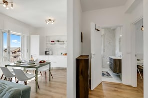 A modern interior with a dining area, kitchen, and bathroom.