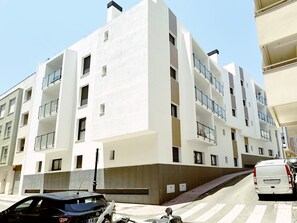 A multi-story building with balconies, a pedestrian ramp, and a parked van. - Salara Living by Lica (Estepona)