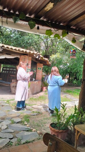 Un espacio rústico al aire libre con un edificio de ladrillo, un sendero de piedra y plantas en macetas.