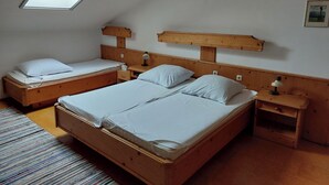 Une chambre à coucher avec deux lits en bois, une lucarne et une tête de lit en bois.