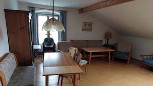 Un salon chaleureux avec une table à manger en bois, deux canapés et un fauteuil.