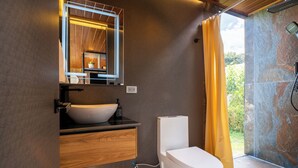 Een moderne badkamer met een wit wastafelmeubel, een spiegel en een douchecel.