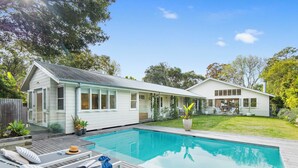 Ein modernes Haus mit Swimmingpool, einer Sonnenterrasse und einem gepflegten Garten.