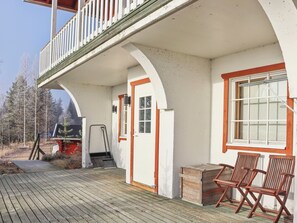 A wooden deck with a covered area, a door, and two wooden chairs. - Mukalilla, paritalo sis loppusiivouksen by Interhome (Hyrynsalmi)