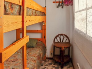 A bunk bed with a patterned mattress, a wooden chair, and a window with a view of the outside. - Mukalilla, paritalo sis loppusiivouksen by Interhome (Hyrynsalmi)
