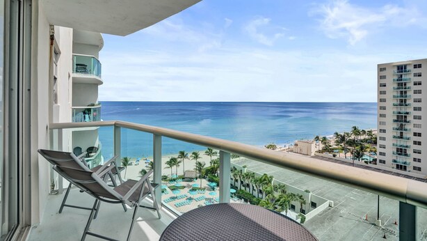 A balcony with a view of the ocean and a pool area. - Beachfront Getaway | Direct Ocean Views + Balcony (Hollywood)