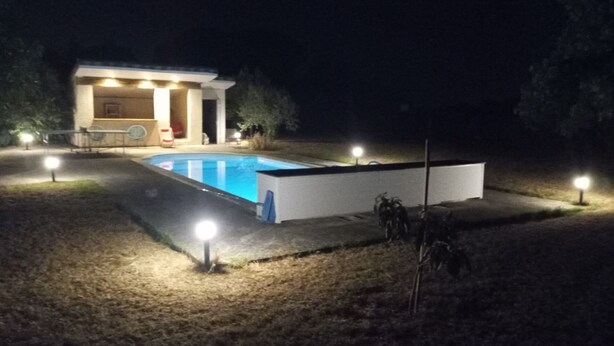 A pool area with a small building, possibly a pool house, and a covered seating area. - House and pool (Fontenilles)
