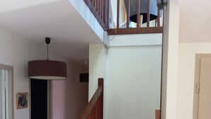 A staircase with wooden railings and terracotta steps leading to a second floor. - House and pool (Fontenilles)