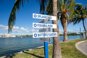 A directional signpost with multiple arrows pointing towards Splash Park, Fishing Pier, Playground, Butterfly Garden, and Tennis Courts.