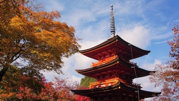 A traditional multi-tiered pagoda with a spire, surrounded by autumn foliage.