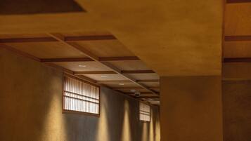 A hallway with wooden beams and a ceiling with recessed lighting.