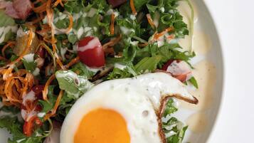 Un plato con ensalada y un huevo frito.