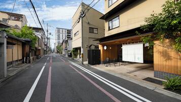 A street with buildings, a restaurant with outdoor seating, and a clear sky.
