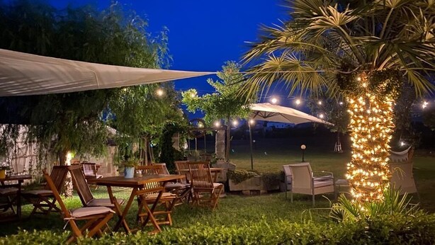 Eine Außenpatio-Terrasse mit Holzmöbeln und Lichterketten.
