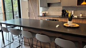 Une cuisine moderne dotée d’un grand îlot central, de tabourets de bar et d’une porte coulissante de style rustique.