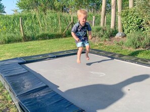 Un niño saltando en un trampolín.