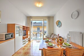 A dining area with a table set for two, a microwave, and a view of the outside. - Casa Silvia 50m From The Lake (Arco)