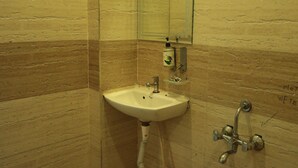 A bathroom with a sink, mirror, and shower. - Green Valley Palace (Bhopal)