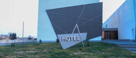 Un moderno edificio de hotel con un llamativo letrero que dice 'HOTEL' al frente.
