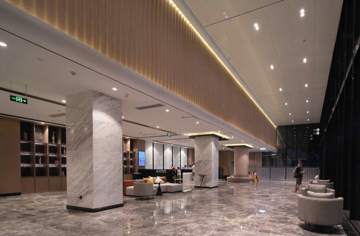 Un'ampia hall con pavimento in marmo, grandi colonne e una reception.
