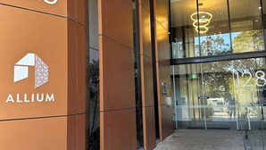 Entrada moderna de un edificio con el número 128 y el nombre 'ALLIUM' en la pared.