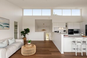A modern interior with a living area, kitchen, and dining space. - Bella Haven | Panoramic Coastal Views | Sleeps 10 (Fairhaven)