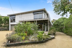 A two-story modern house with a balcony, surrounded by a landscaped garden. - Fairhaven Oasis I Ocean and Lighthouse Views (Fairhaven)