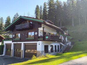 A multi-story building with a balcony, a garage, and a staircase leading to the upper floor.