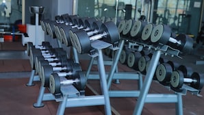 A row of adjustable dumbbells in a gym.