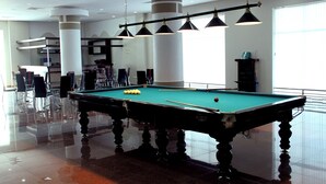 A pool table with balls, overhead lighting, and a bar area in a well-lit indoor space. - Arena Hotel Gazakh (Gazakh)