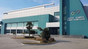 A modern building with a prominent Olympic rings logo, indicating it is an Olympic complex. - Arena Hotel Gazakh (Gazakh)