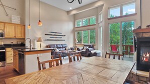 A spacious kitchen with wooden cabinets, a dining table, and a fireplace.
