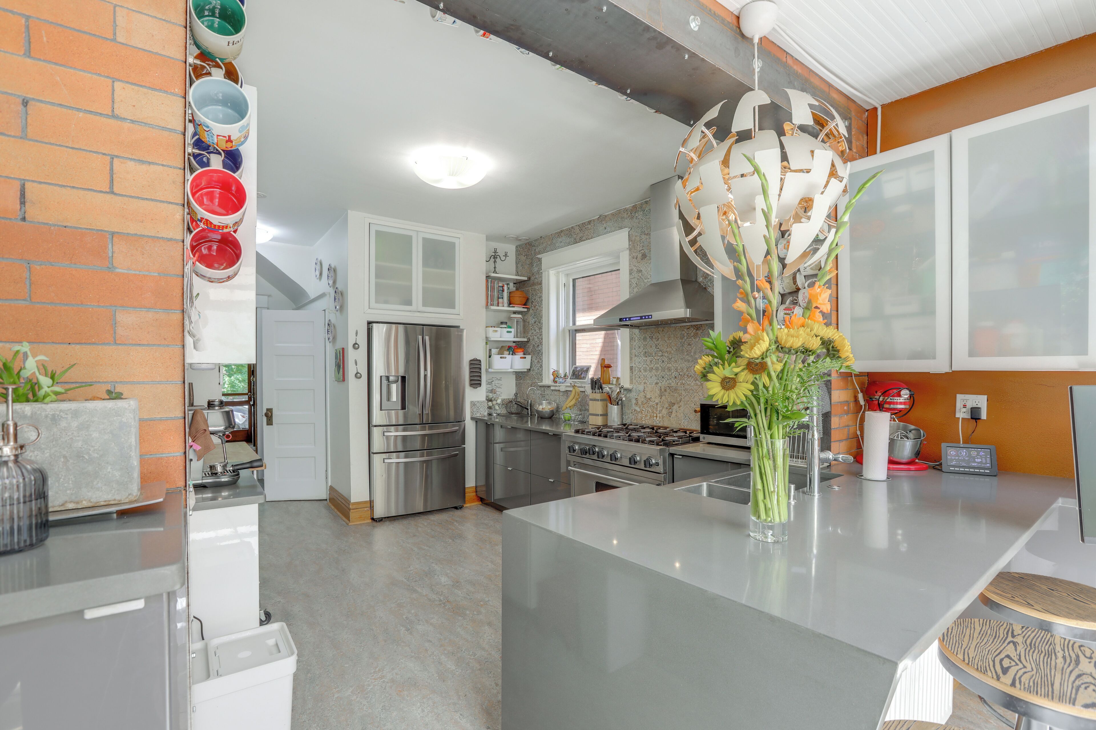 A modern kitchen with stainless steel appliances, a central island, and a decorative vase.