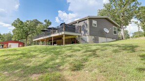 A two-story house with a covered patio and a garage. - Outdoor Kitchen + Hot Tub: Table Rock Lake House (Golden)