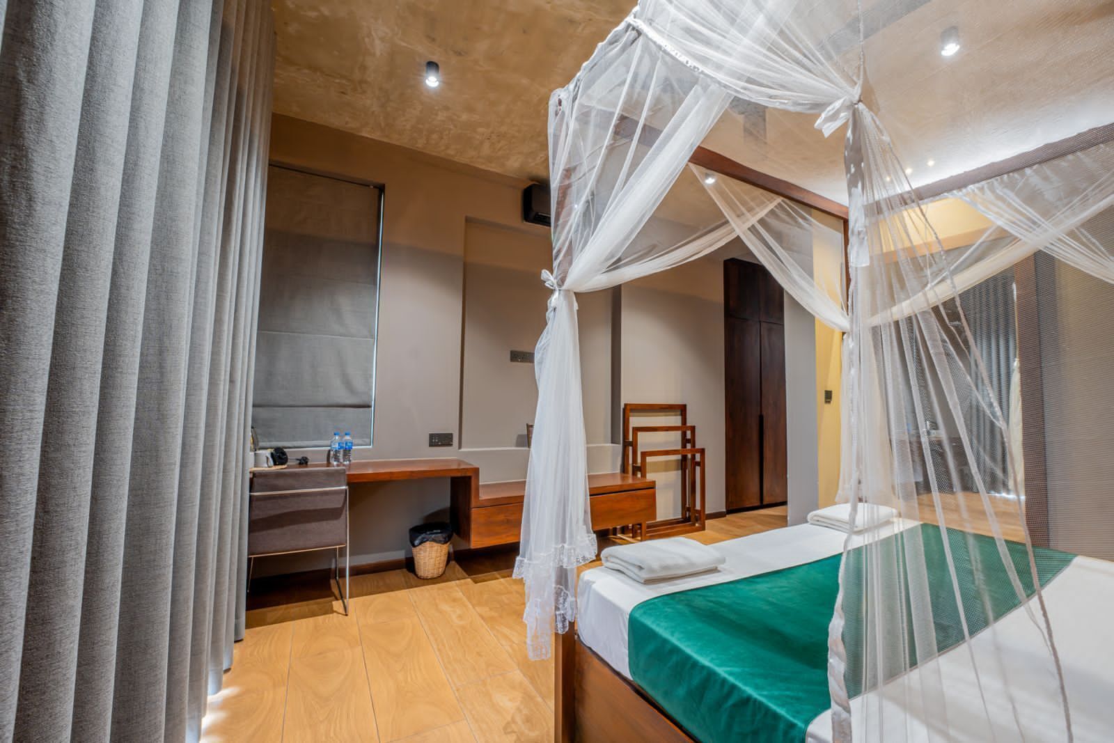 A bedroom with a bed, bedside table, and a desk with a chair.