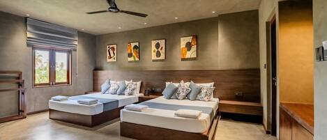 A modern bedroom with two beds, a ceiling fan, and artwork on the walls.