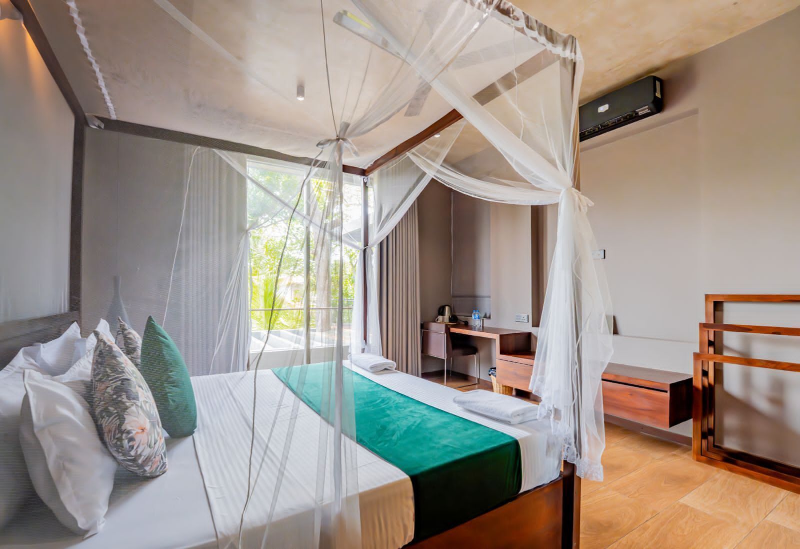 Quarto com cama de dossel, uma escrivaninha e uma cadeira.