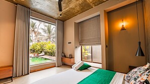 Een moderne slaapkamer met een groot bed, uitzicht op een zwembad en een plafond met zichtbare balken.