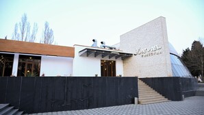 Un bâtiment moderne doté d’une entrée imposante, d’un escalier menant à la porte principale et d’une grande façade en verre.