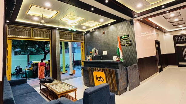 A hotel lobby with a reception desk, sofas, and a tiled floor. - S R HOTEL (Varanasi)
